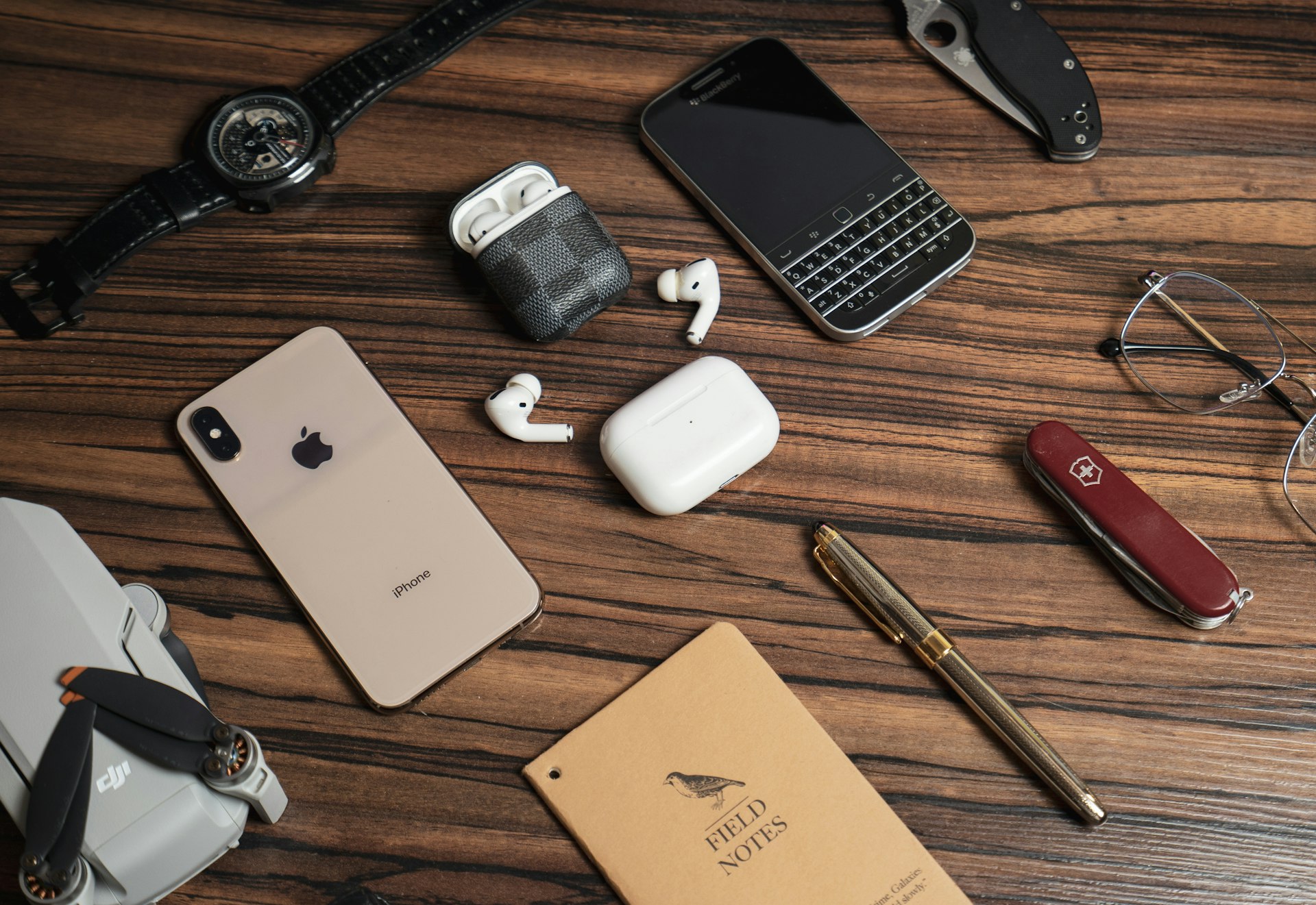 a wooden table topped with different types of electronics
